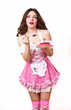 Foto: Young girl like a doll in pink dresses with plate of cake Young girl like a doll in pink dresses with plate of cake