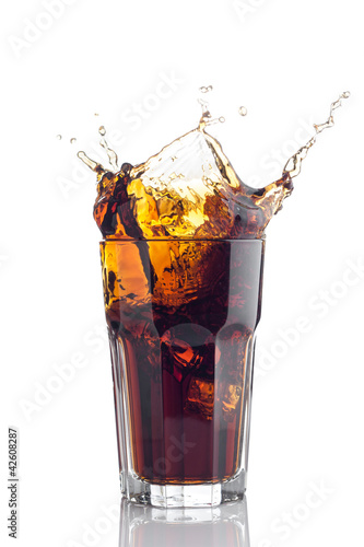 Photo: splash in glass of cola with ice cubes splash in glass of cola with ice cubes