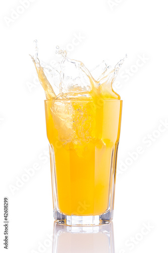 Photo: splash in glass of orange soda with ice cubes splash in glass of orange soda with ice cubes