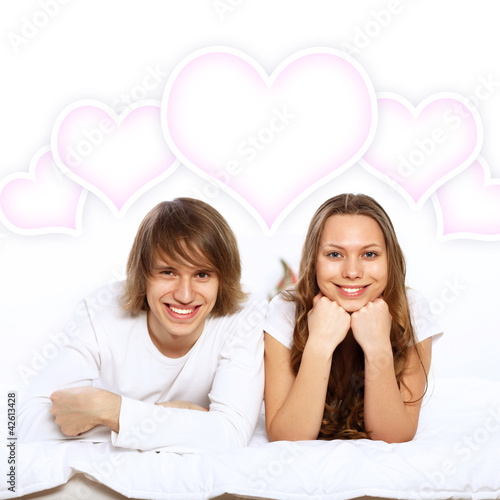 Photo: Young couple in white with heart symbols Young couple in white with heart symbols