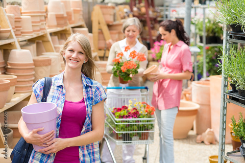 Photo: Woman holding purple pot in garden center Woman holding purple pot in garden center