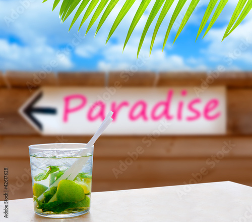 Photo: Cocktail mojito in a written paradise word arrow sign Cocktail mojito in a written paradise word arrow sign