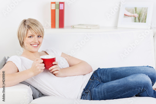Foto: entspannte frau mit tasse auf dem sofa entspannte frau mit tasse auf dem sofa