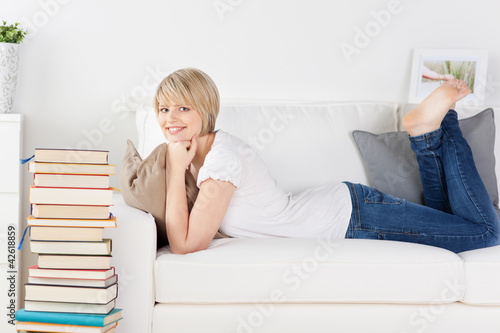 Photo: frau mit einem stapel bücher auf dem sofa frau mit einem stapel bücher auf dem sofa