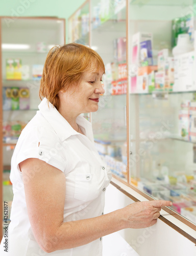 Photo: woman near counter in pharmacy woman near counter in pharmacy