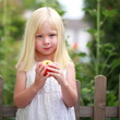 kleines Mädchen isst Apfel - draußen