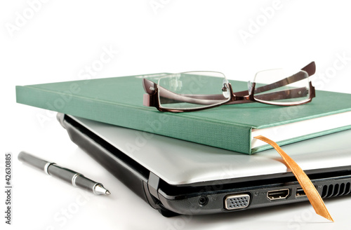 Photo: Glasses and Green Book put on Laptop Glasses and Green Book put on Laptop
