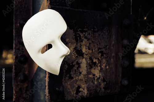 Photo: Masquerade - Phantom of the Opera Mask on Rusty Bridge Column Masquerade - Phantom of the Opera Mask on Rusty Bridge Column