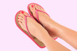 Photo: female legs in pink sandals on pink background female legs in pink sandals on pink background