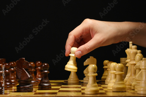 Photo: Chess board with chess pieces isolated on black Chess board with chess pieces isolated on black