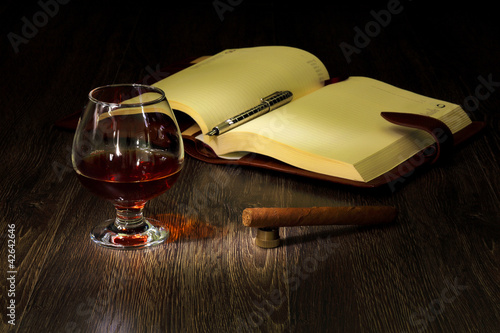 Photo: Cognac, cigar and an old book nearby Cognac, cigar and an old book nearby
