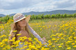 Foto: Sommer-Glück: Junge Frau mit Strohhut auf Blumenwiese Sommer-Glück: Junge Frau mit Strohhut auf Blumenwiese