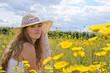 Sommer-Glück: Mädchen mit Strohhut auf Blumenwiese