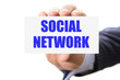 Hand holding card with inscription social network