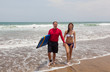 Happy man and the girl go together on an ocean coast