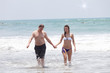 Happy man and the girl go together on an ocean coast