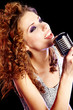 Foto: woman holding a retro microphone woman holding a retro microphone
