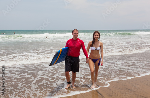 Photo: Happy man and the girl go together on an ocean coast Happy man and the girl go together on an ocean coast