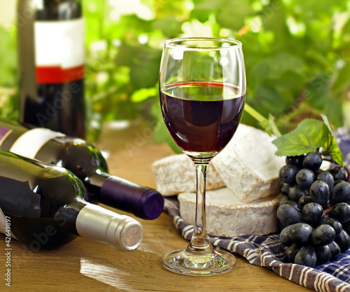 Photo: Red wine, Brie, Camembert and grape on the table, outdoor Red wine, Brie, Camembert and grape on the table, outdoor