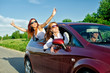 Photo: Two pretty happy girls in the car. Concept of carefree roadtrip Two pretty happy girls in the car. Concept of carefree roadtrip
