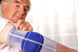 Senior mit Schmerzen und Armbinde