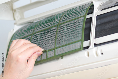 Foto: Removing dirty air-conditioner filter for cleaning Removing dirty air-conditioner filter for cleaning