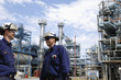 oil and gas engineering with refinery in background