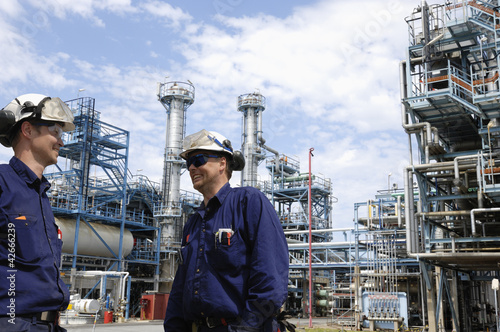 Photo: oil and gas engineering with refinery in background oil and gas engineering with refinery in background