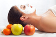Beautiful young woman with natural facial mask on her face