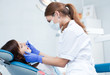 Foto: A young female dentist working in her office. A young female dentist working in her office.