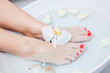 woman spa pedicure foot treatment with water and flower