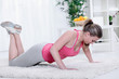 Young beautiful sportswoman exercising (doing push-up).