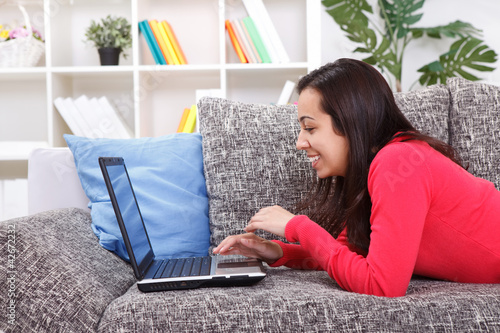 Photo: young woman spending time on laptop computer young woman spending time on laptop computer