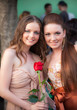 Outdoor lifestyle portrait two young girlfriend with red rose