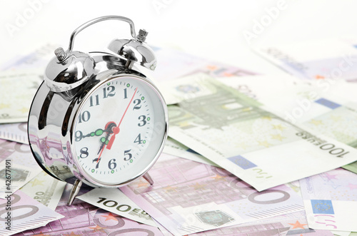Foto: Alarm clock for euro banknotes isolated on white Alarm clock for euro banknotes isolated on white