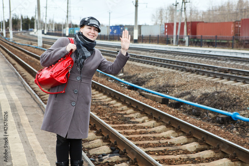 Photo: Happy fashion young woman standing on railway station Happy fashion young woman standing on railway station