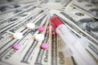 pills and a syringe on a background of money