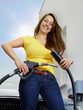 Foto: Woman holding variant types of gas pump nozzle outdoors Woman holding variant types of gas pump nozzle outdoors