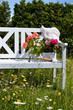 Foto: weiße Gartenbank auf einer Blumenwiese weiße Gartenbank auf einer Blumenwiese