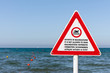 Foto: A no swimming sign on a pole in 5 languages A no swimming sign on a pole in 5 languages