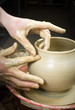 hands of a potter, creating an earthen jar on the circle