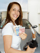 Woman is happy to save money for fuel at fillig station