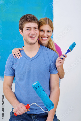Photo: happy couple paint wall at new home happy couple paint wall at new home