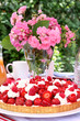 Foto: Erdbeer-Himbeer-Sahne-Kuchen auf Gartentisch Erdbeer-Himbeer-Sahne-Kuchen auf Gartentisch