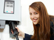 Foto: Pretty woman loading electrically powered car outdoors Pretty woman loading electrically powered car outdoors