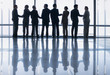 Business people shaking hands in a row at lobby window