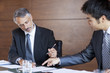 Businessmen signing paperwork