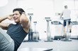 Smiling man doing sit-ups in gymnasium