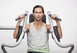 Portrait of man using exercise equipment in gymnasium