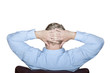 Foto: Man sitting on a chair with folded arms behind the head Man sitting on a chair with folded arms behind the head